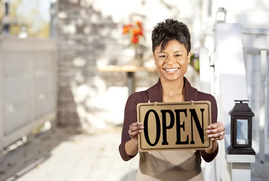 woman holding OPEN sign